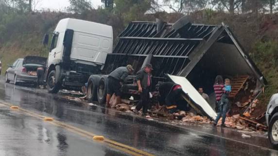 Diversos veículos estacionavam no acostamento da rodovia e deixavam o local carregado com os produtos saqueados do caminhão