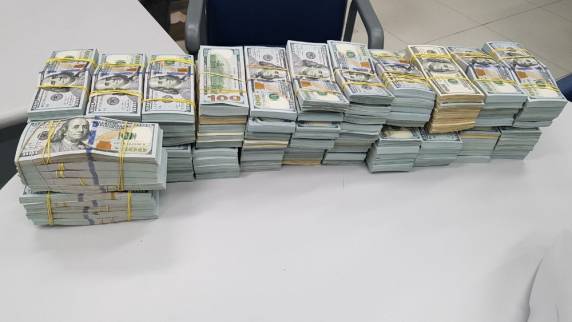 Apreensão foi feita em um posto de fiscalização da BR-116, na Grande Curitiba; a quantia estava dividida em dólares e reais. Homem disse à polícia que não sabia do dinheiro