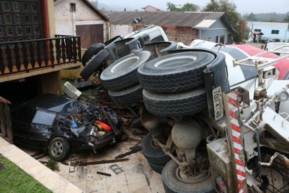 Um dos motoristas teve ferimentos leves, mas passa bem. Carro que estava estacionado na garagem da residência foi 

arrastado, e ficou totalmente destruído