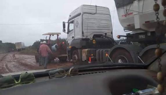 Carreta atolou e precisou do auxílio de trator para tentar sair do local