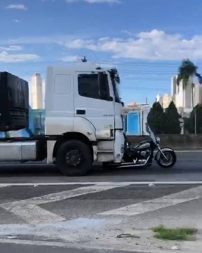 Um casal estava na moto. A mulher caiu na pista e não resistiu aos ferimentos. O homem conseguiu se agarrar ao caminhão e alcançou a janela do motorista, que se negou a parar