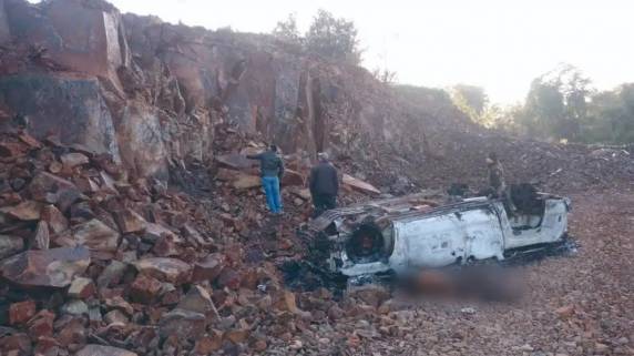 O cadáver foi encontrado por populares ao lado de um veículo acidentado e incendiado, em uma pedreira