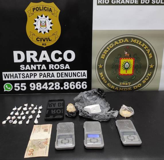 Foram encontrados no local 26 buchas de cocaína prontas para a venda totalizando 10g, uma porção de cocaína pesando 60g, duas porções de crack totalizando 25g, 03 balanças de precisão, um telefone celular e R$ 50,00 em moeda corrente.