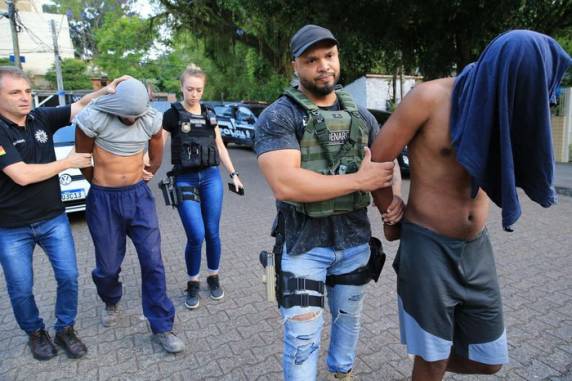 Os dois homens já foram detidos, mas a mulher segue sendo procurada; agentes cumprem cinco mandados de busca e cinco de prisão nesta sexta-feira