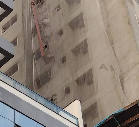 Segundo os bombeiros, estrutura que dava suporte aos funcionários ficou pendurada por apenas um dos lados. Eles trabalhavam em uma obra em Itapema.