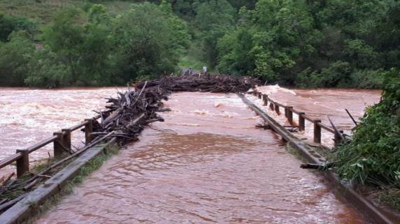 Conforme informou um morador, no início da tarde, praticamente metade da ponte ficou coberta de troncos e galhos de árvores