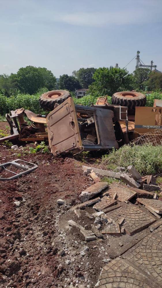 A carregadeira, após a colisão com a camionete, tombou em um terreno baldio nas proximidades.
