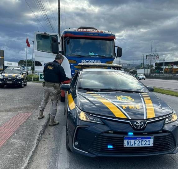 A carreta que ele conduzida estava parada sobre a pista na via marginal, trancando a saída de um posto de combustíveis.