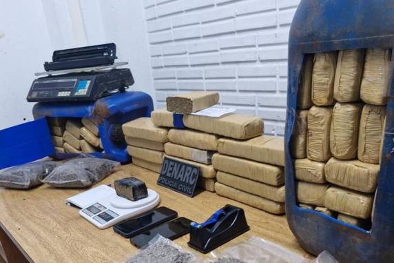 Um homem foi preso em flagrante ao sair do imóvel; também foram recolhidas balanças de precisão, uma prensa hidráulica, uma seladora e cadernos de anotação