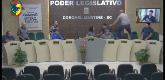 Imagens mostram Arlenio Cecatto (PT) correndo atrás de Luiz Carlos Savi (PSD), que dá voltas em torno da mesa e em meio a outros políticos. Caso aconteceu na segunda-feira.
