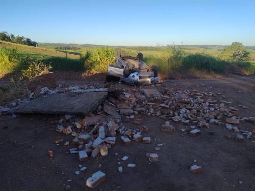 Com o impacto, a estrutura da parada foi destruída e o automóvel acabou capotando, parando com as rodas para cima na lateral da via.
