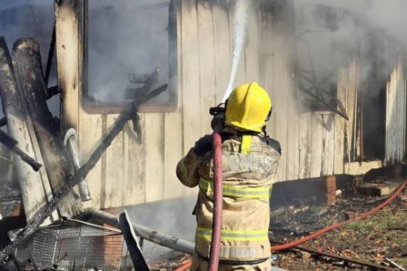 Menina de 7 anos foi socorrida por vizinhos e não se feriu. Incêndio destruiu a residência de madeira