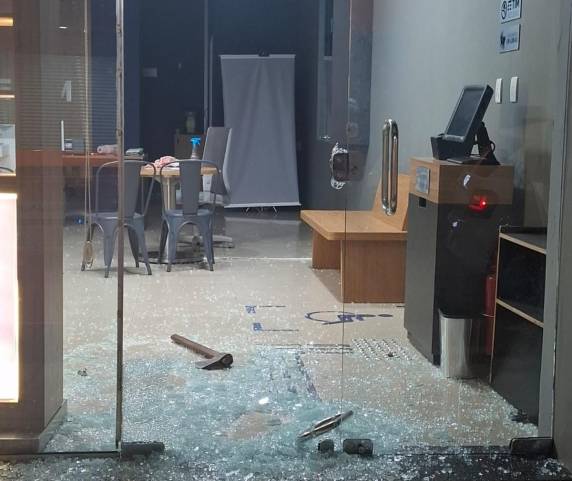 Criminosos quebraram porta de vidro durante a noite e fugiram levando notebooks e celulares; machado foi deixado no local